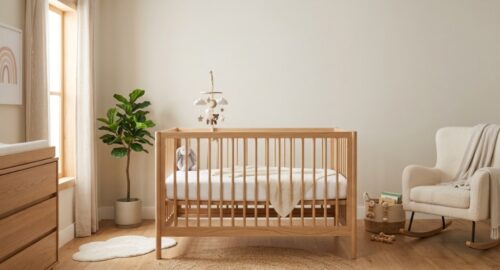 A clean, modern wooden baby crib with a firm white mattress in a sunlit nursery.