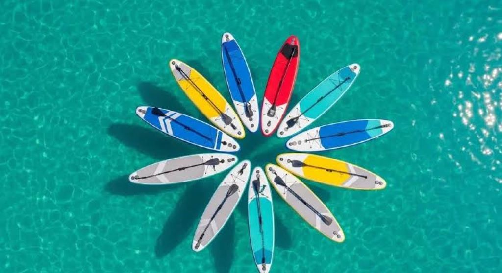 Beginner paddling a SUP board on sunny beach during summer adventure